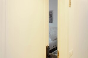 Een hotelkamer met een bed, nachtkastje en een kunstwerk aan de muur.