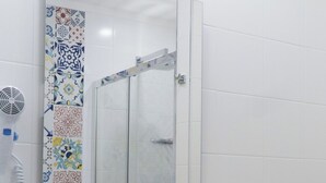 Ein Badezimmer mit einem weißen Waschbecken, einem Spiegel und einem Fön an der Wand.