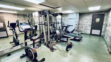 A gym with various exercise equipment, including treadmills, weight machines, and a stationary bike.
