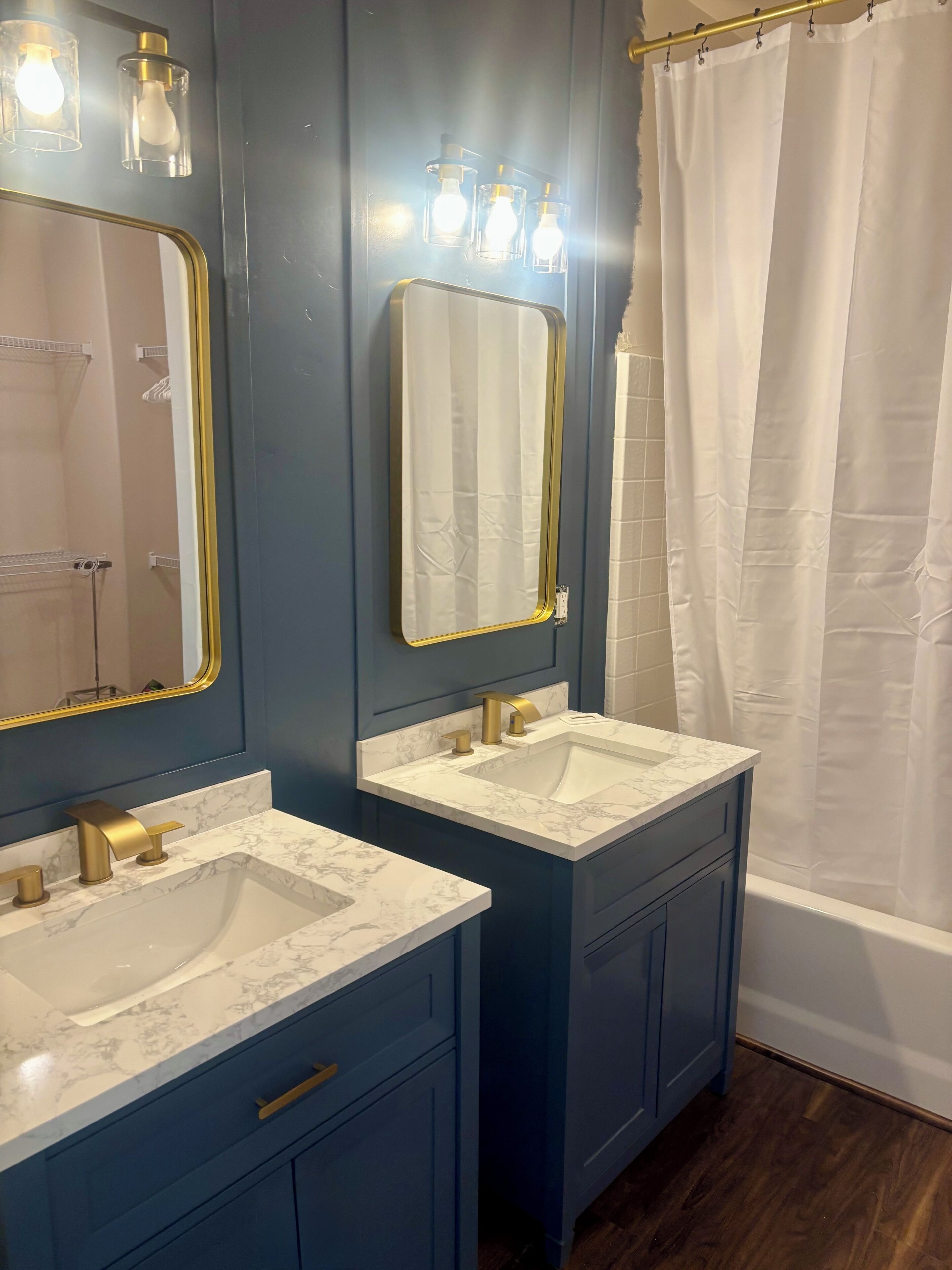 Een badkamer met twee wastafels, een spiegel en een douchegordijn.