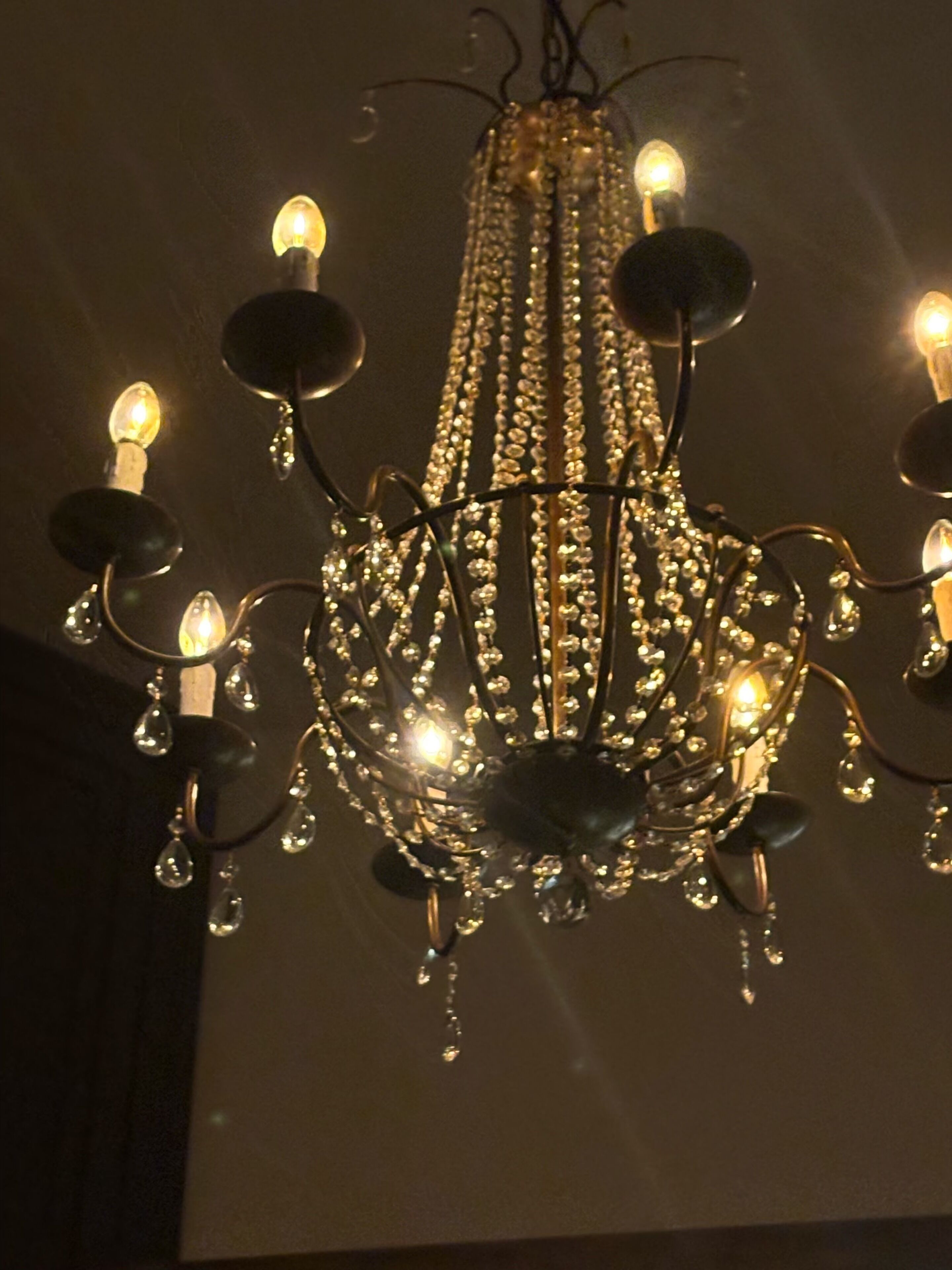Un lustre orné de plusieurs ampoules et de décorations en cristal.