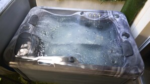 A hot tub with three jets, a built-in speaker, and a small window. - La Romance Room - Jacuzzi | Cinema | Sauna (Arnouville)