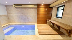 A modern spa room with a hot tub, wooden benches, and a small window. - Cosy mountain house with heated pool (Beuil)
