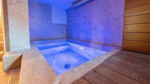 A modern spa room with a rectangular hot tub, tiled walls, and wooden flooring. - Cosy mountain house with heated pool (Beuil)