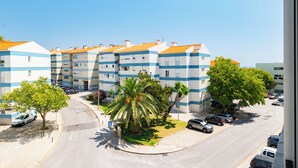 A multi-story residential building with a curved driveway and parked cars. - Great remodeled apartment - 5 min to the beach! (Carcavelos)