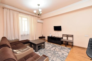 Departamento Confort, vista a la ciudad | Área de sala de estar | Televisión de pantalla plana de 50 pulgadas con canales por cable