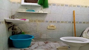A small bathroom with a sink, toilet, and a blue bucket. - Sweet sleep (Casablanca)