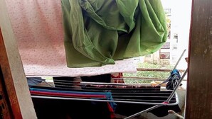 A balcony with a clothesline holding a green garment and a patterned cloth. - Sweet sleep (Casablanca)