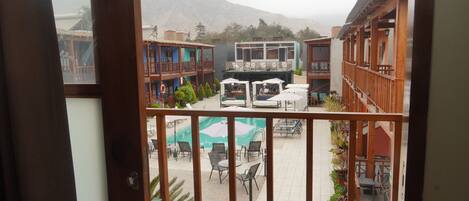 A courtyard with outdoor seating, a pool, and mountain views.