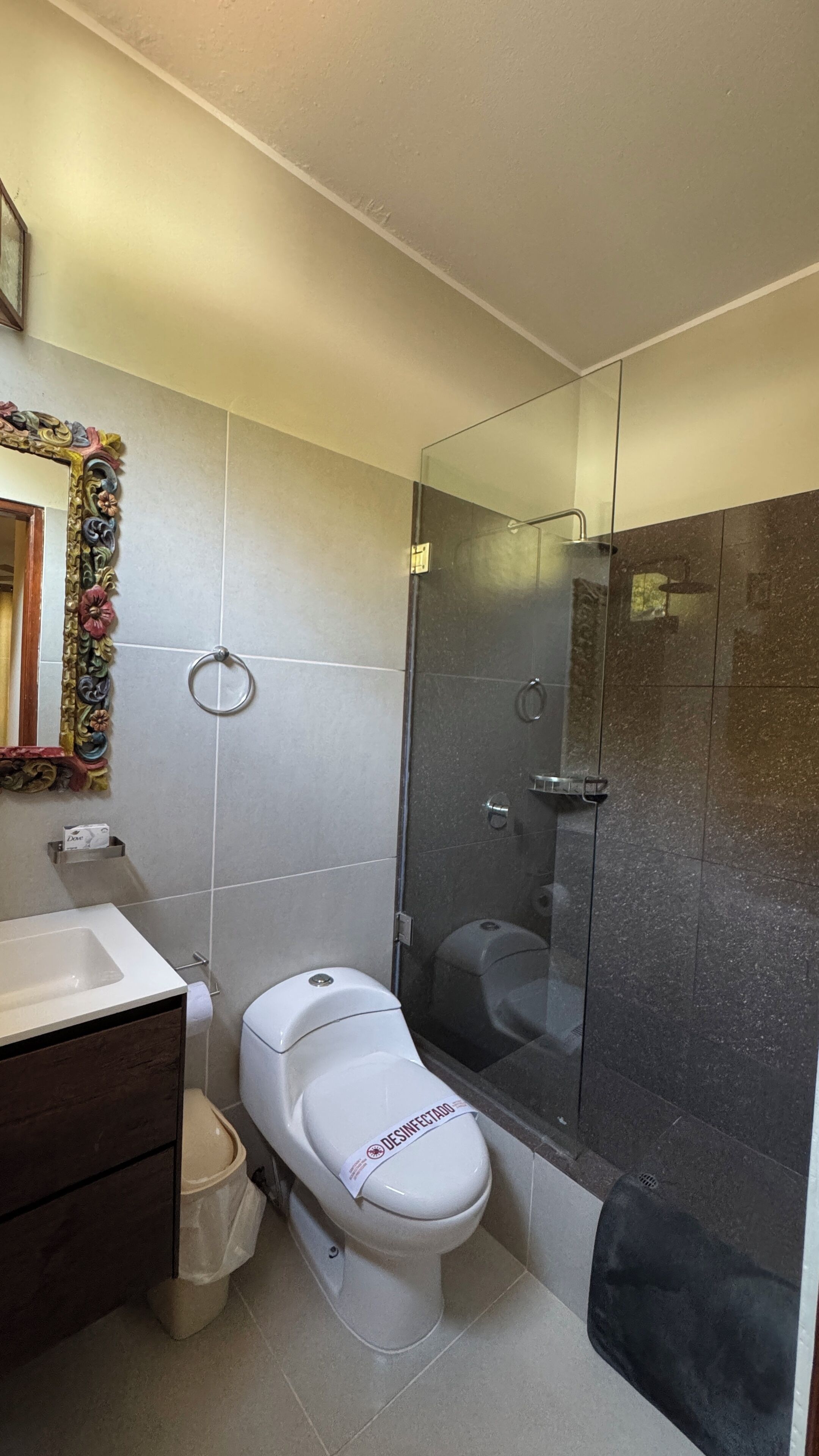 A modern bathroom with a toilet, bidet, and glass shower enclosure.