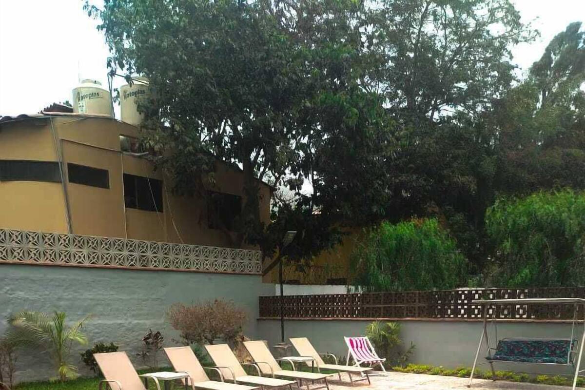 Una piscina con sillas de descanso y un deck con baldosas.