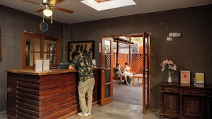 A reception area with a wooden counter, a ceiling fan, a skylight, and a clock. - Casa de Campo Bungalows & Suites (Cieneguilla)