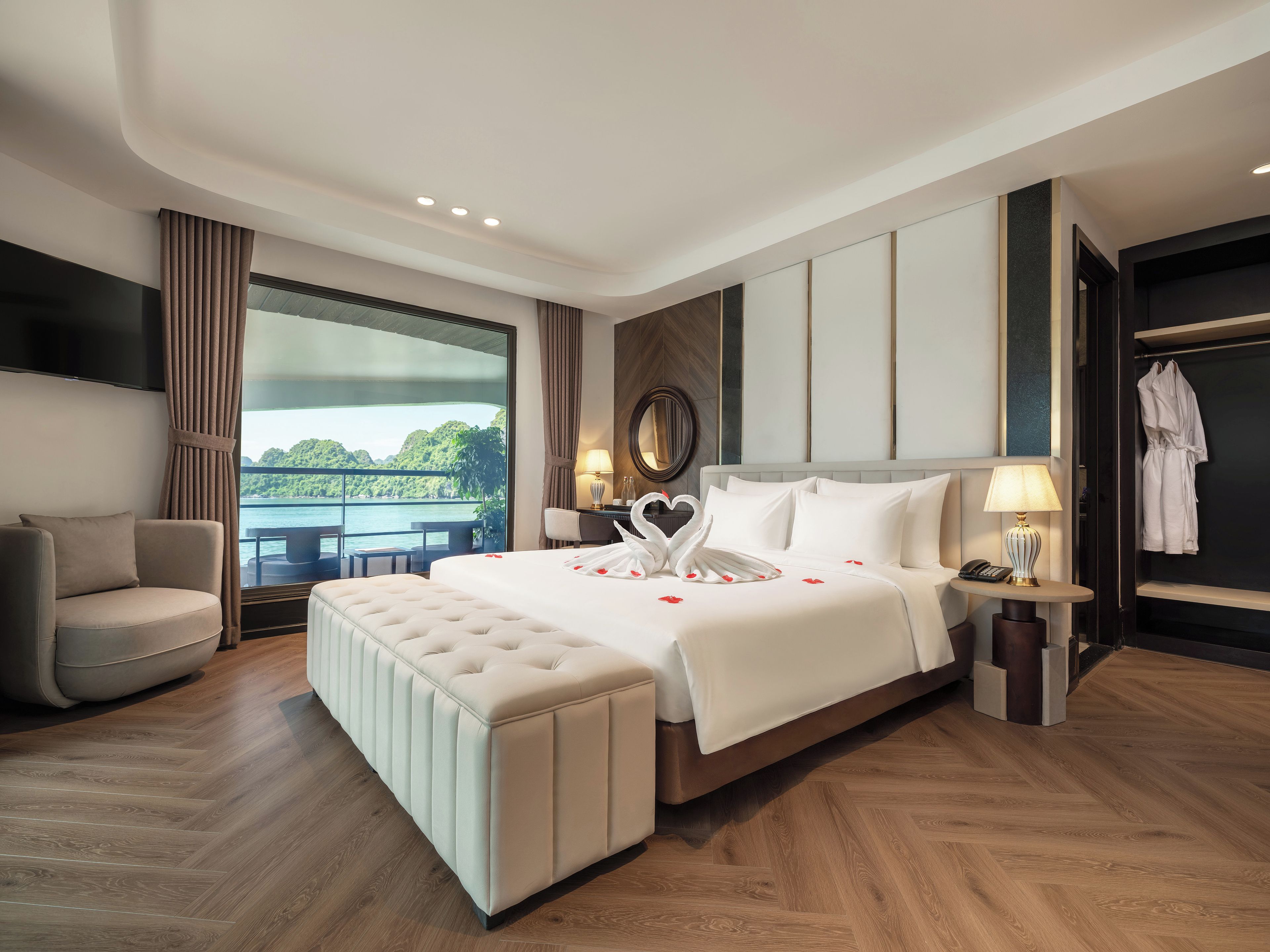A modern hotel room with a large bed, a seating area, and a view of the outdoors.