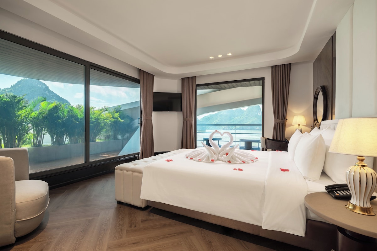 Une chambre d’hôtel dotée d’un grand lit, d’un coin salon et offrant une vue sur un paysage montagneux.