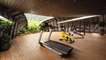 A gym with treadmills, an elliptical, and dumbbells.