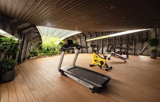A gym with treadmills, an elliptical, and dumbbells.