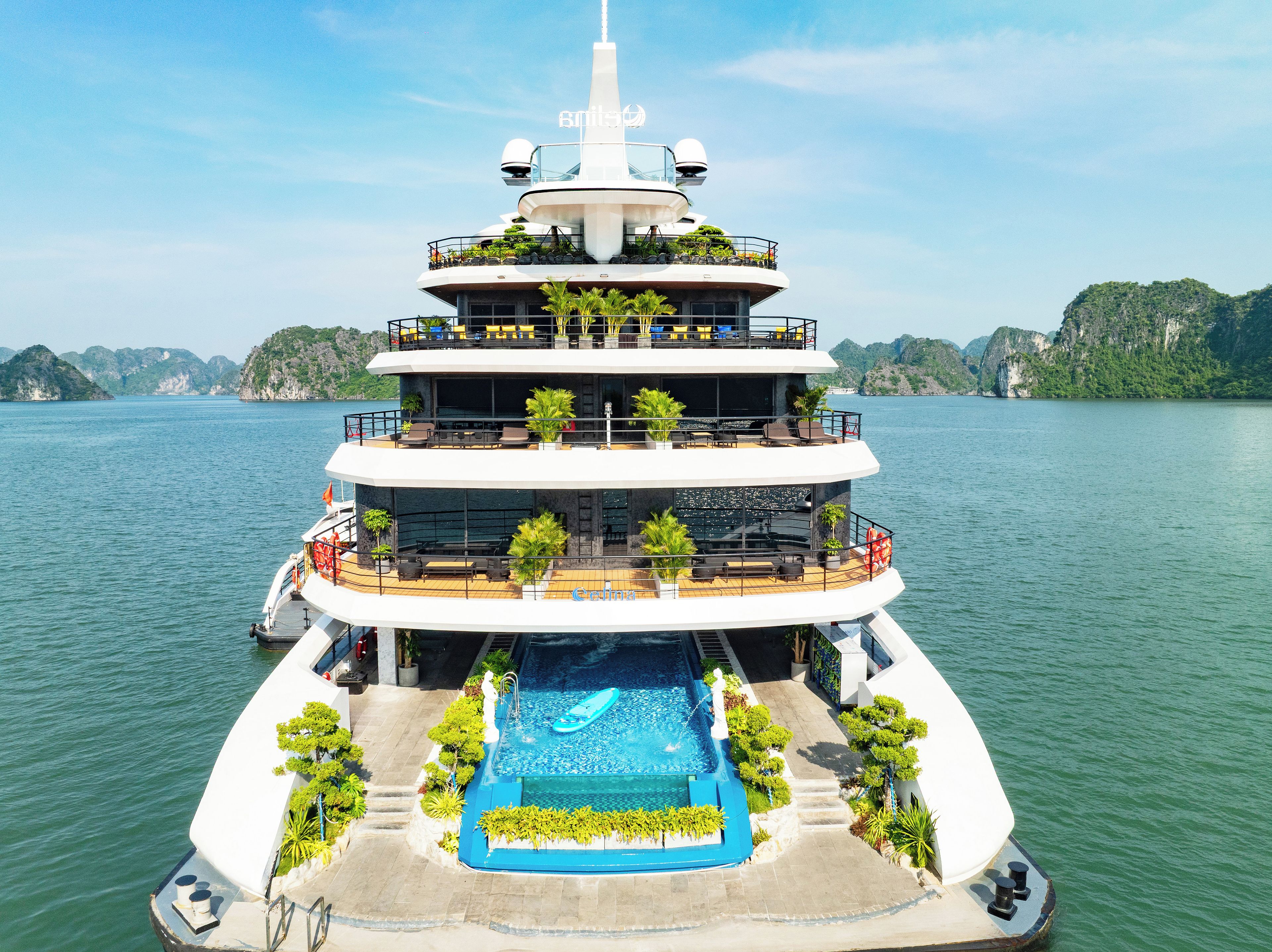 A multi-level yacht with a swimming pool, outdoor seating, and a helipad.