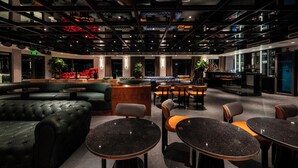 A modern lounge area with seating arrangements, a bar, and a well-lit ceiling with exposed beams. - Celina of The Sea Cruise (Tuan Chau)