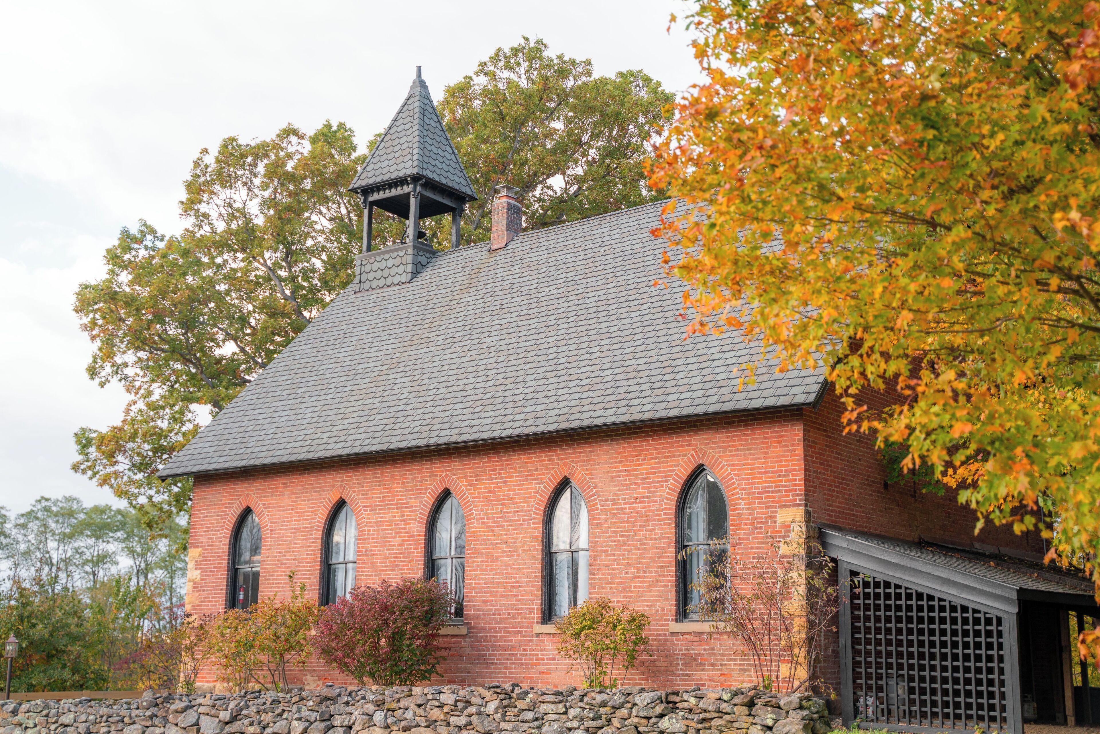 A brick building with a gabled roof and a bell tower.