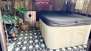 Una habitación con una cama, un panel de madera con una cita motivacional, una planta pequeña y un suelo estampado.