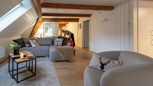 Een gezellige woonkamer met een modulaire bank, een klein tafeltje met een kaars en een potplant.