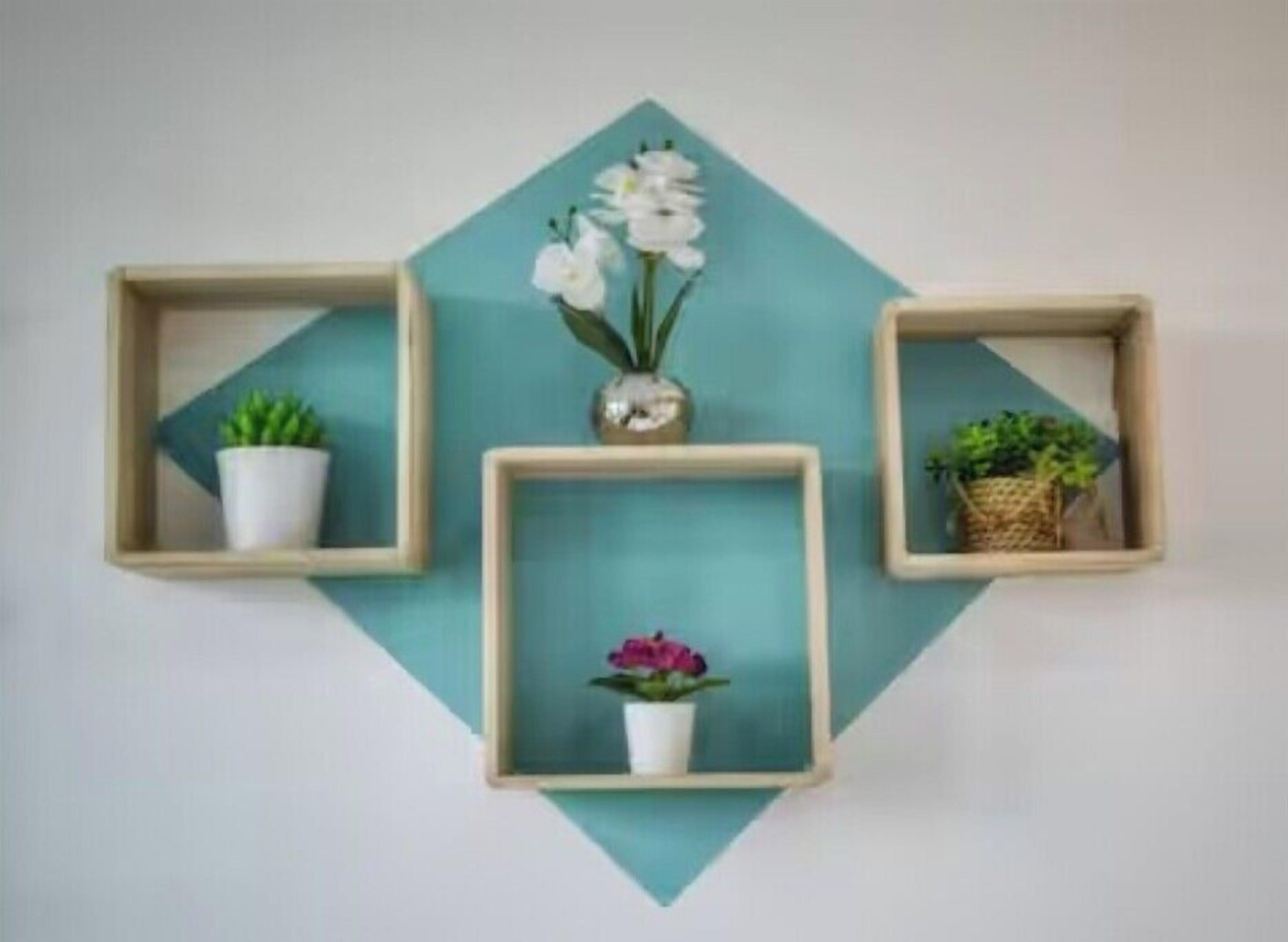 Three wall-mounted wooden shelves with potted plants and flowers.