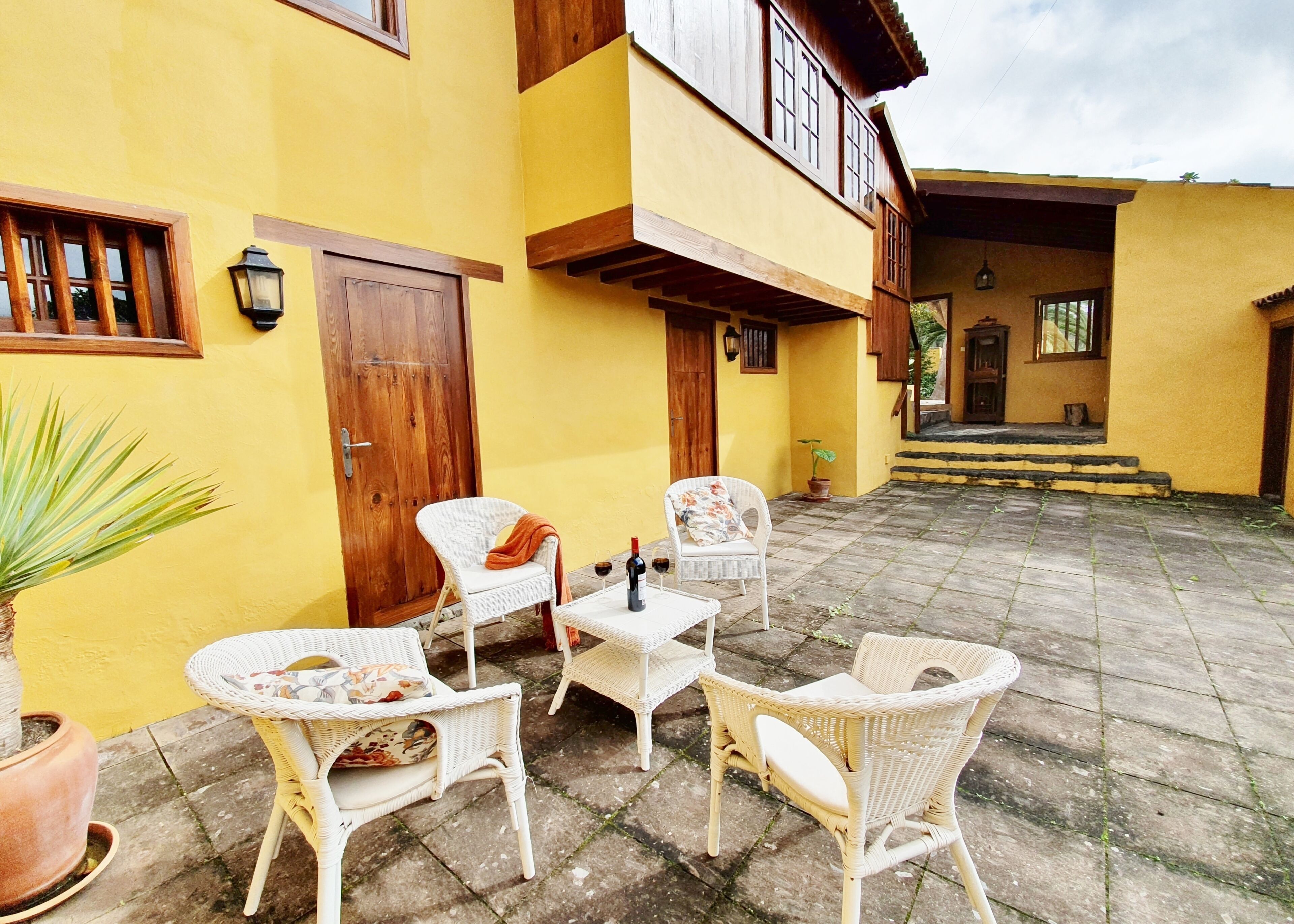 A courtyard with wicker furniture and a potted plant.