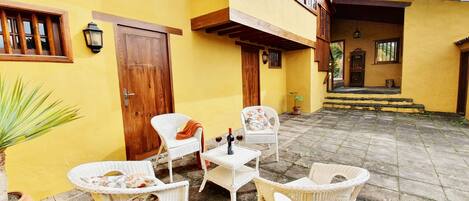 A courtyard with wicker furniture and a potted plant.