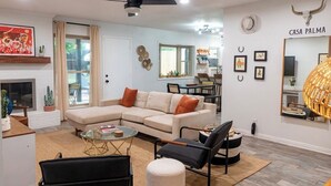 Una sala de estar moderna con un sofá modular, una mesa de centro y un comedor con mesa y sillas.