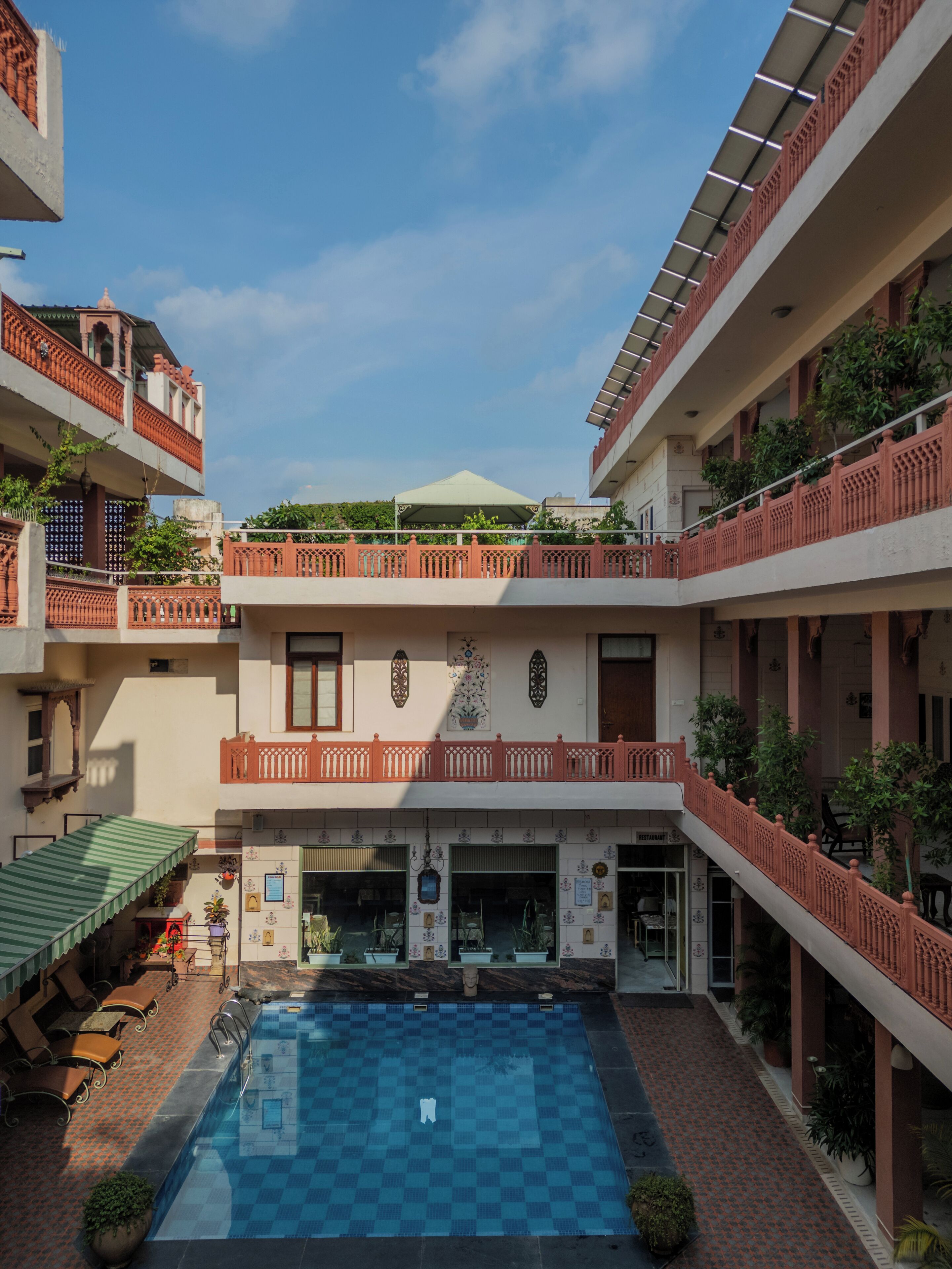 Un patio con piscina, varios balcones y un restaurante.