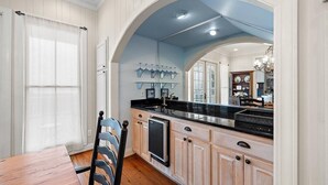 A kitchen with wooden cabinets, a black countertop, and a built-in dishwasher.