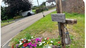 A sign for The Hurst Coach House with a flower bed in front. - The Hurst Stable, 1800 century Coach House offering luxurious amenities, Hottub (Wheaton Aston)