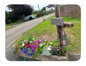 A sign for The Hurst Coach House with a flower bed in front. - The Hurst Stable, 1800 century Coach House offering luxurious amenities, Hottub (Wheaton Aston)