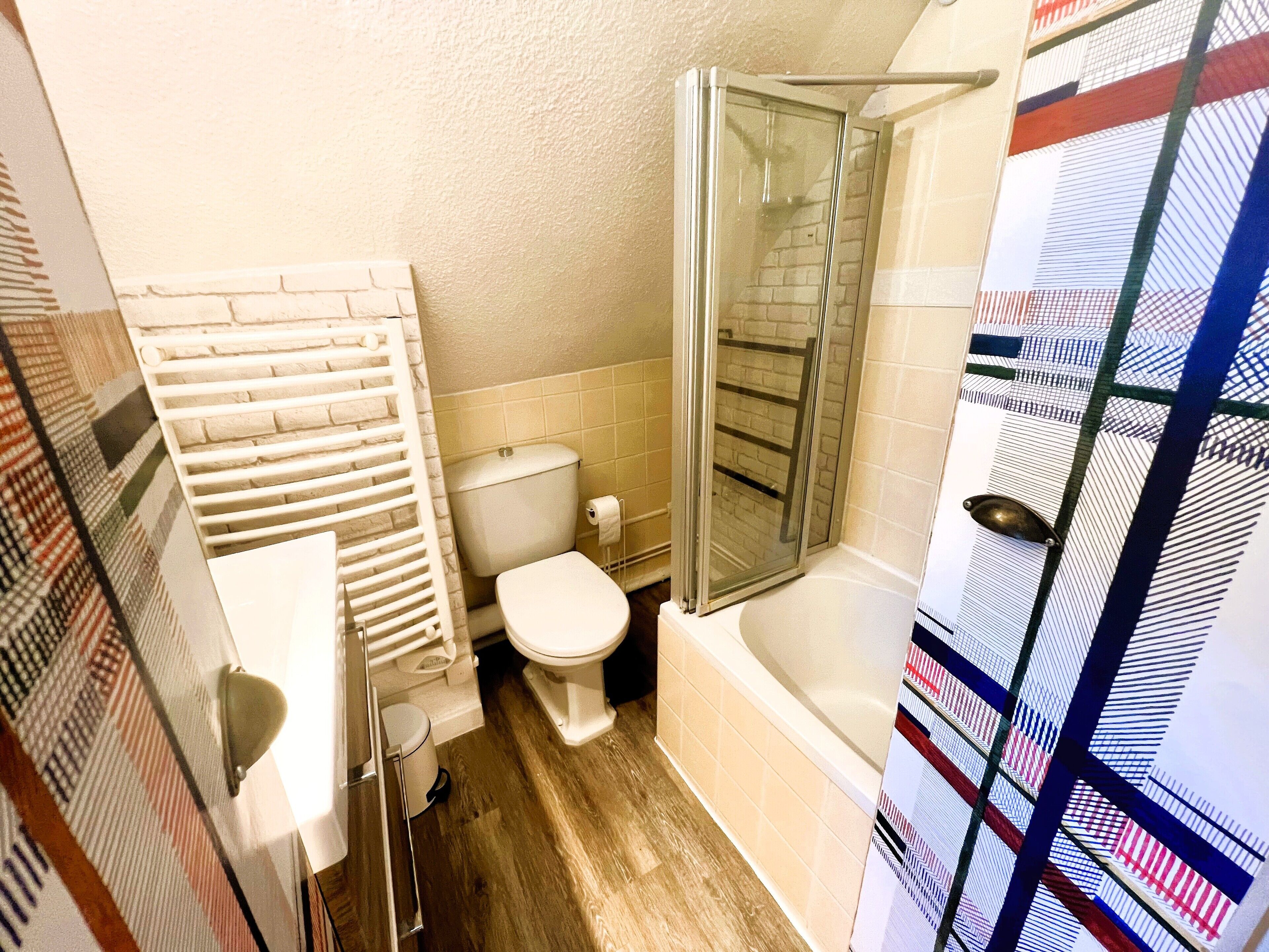 Een badkamer met toilet, douche en een handdoekhouder.