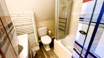 Een badkamer met toilet, douche en een handdoekhouder.