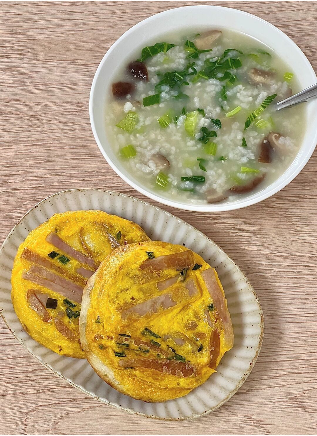 A bowl of soup with rice and vegetables, and two plates of yellow omelette patties.