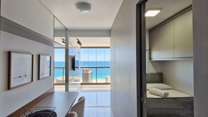 A modern hotel room with a balcony, a dining area, and a bed. - COBAR0129 - Edifício Barra Premium (Salvador)