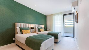 Une chambre d’hôtel moderne avec deux lits, une grande fenêtre avec des rideaux et une vue sur l’extérieur.