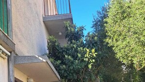 Un edificio de fachada de piedra, con un balcón y una bicicleta estacionada afuera.