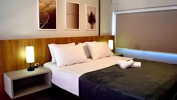Een hotelkamer met een bed, nachtkastjes en wanddecoratie.