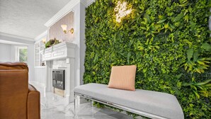 A modern interior with a bench, a fireplace, and a lush green wall.