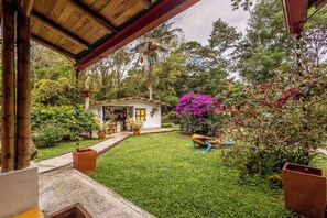 Un espacio al aire libre cubierto con un pequeño edificio, un sendero y abundante vegetación.