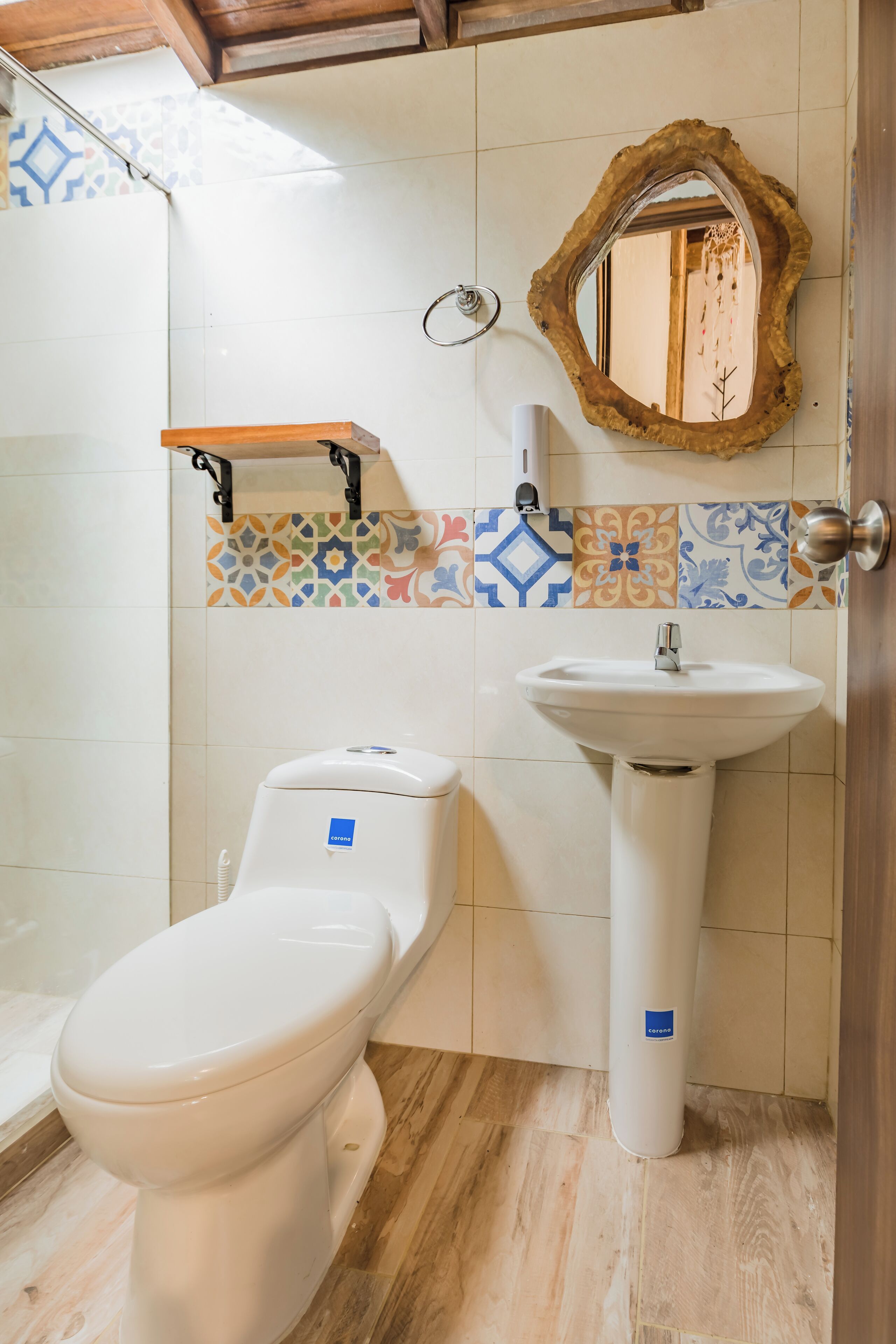 A bathroom with a toilet, a sink, and a mirror.