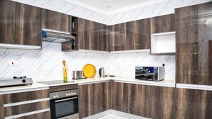 Una cocina moderna con armarios de madera, horno empotrado y microondas.