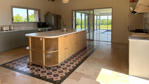 A modern kitchen with a large island, wooden cabinets, and a patterned floor. - Beautiful Villa With Indoor Pool (Sainte-Cecile)