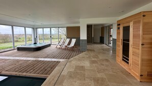 A modern spa area with a hot tub, wooden deck, and a sauna. - Beautiful Villa With Indoor Pool (Sainte-Cecile)