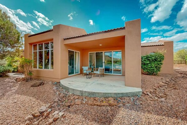 A modern two-story house with a patio, large windows, and a well-maintained garden. - NEW! Relaxing Red Rock Retreat with Patios & Views (Sedona)