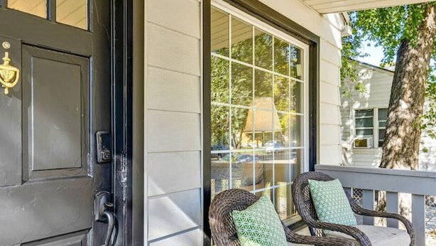 A porch with two wicker chairs, a black door, and a glass door leading to a covered area. - Nest & Nook • 2 Units, 2 Mins from BYU (Provo)