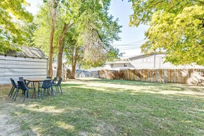 A backyard with a wooden table and chairs, surrounded by trees and a fence. - Nest & Nook • 2 Units, 2 Mins from BYU (Provo)