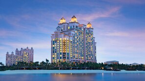 Un hotel di grandi dimensioni con numerosi balconi, una piscina e vista sulla spiaggia.